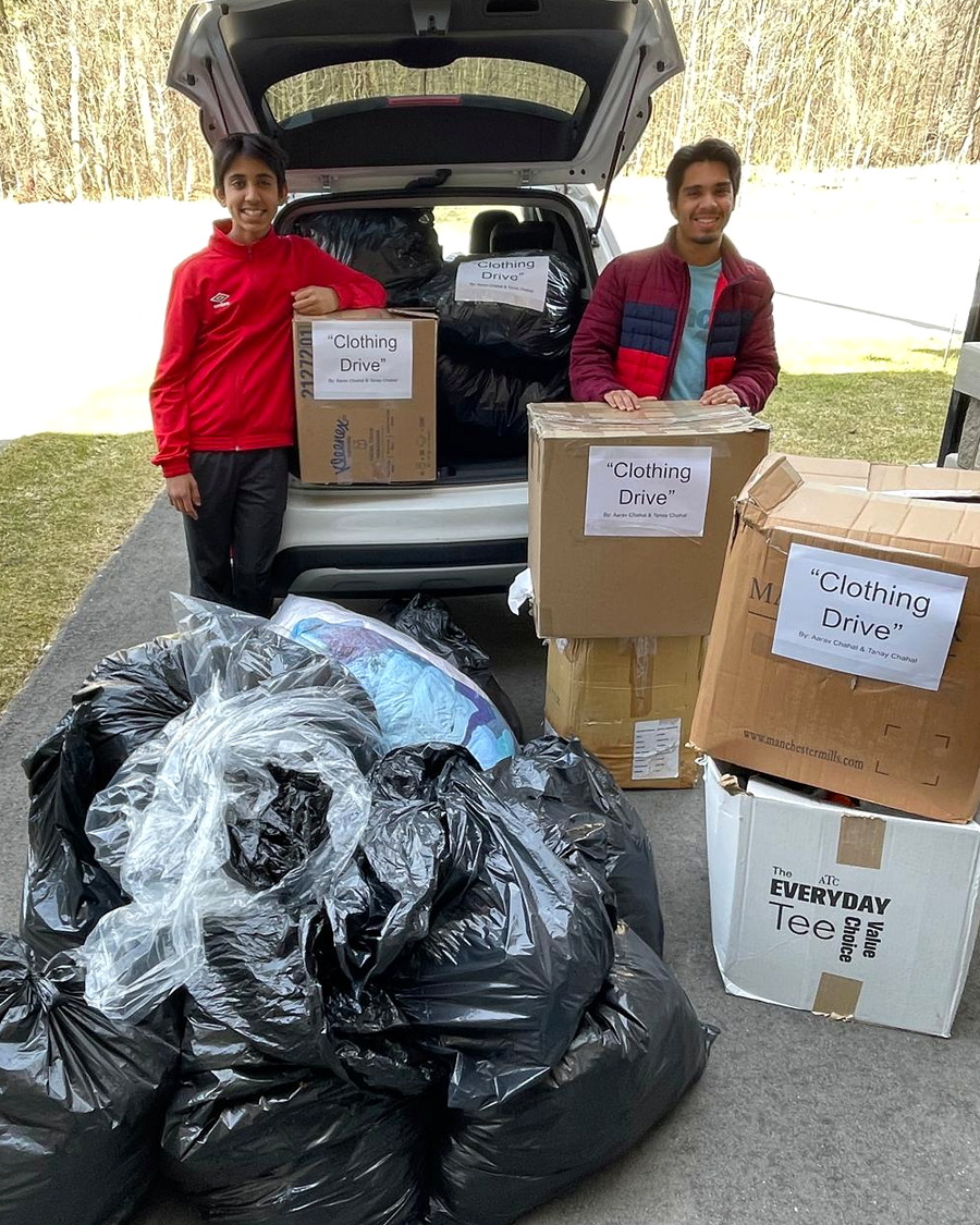 Boxes and bags of donations collected for a clothing drive, loaded into a car